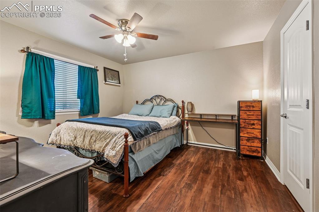 Image 28 of 38: Bedroom featuring dark wood finished floors and a ceiling fan