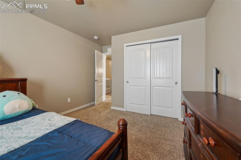 Image 29 of 38: Bedroom with light carpet, a closet, and a ceiling fan