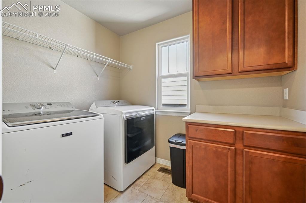 Image 32 of 38: Laundry room with cabinet space, independent washer and dryer, a textured w