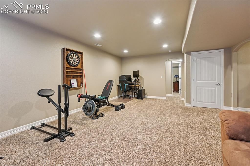 Image 33 of 38: Workout area featuring arched walkways, recessed lighting, and light colore