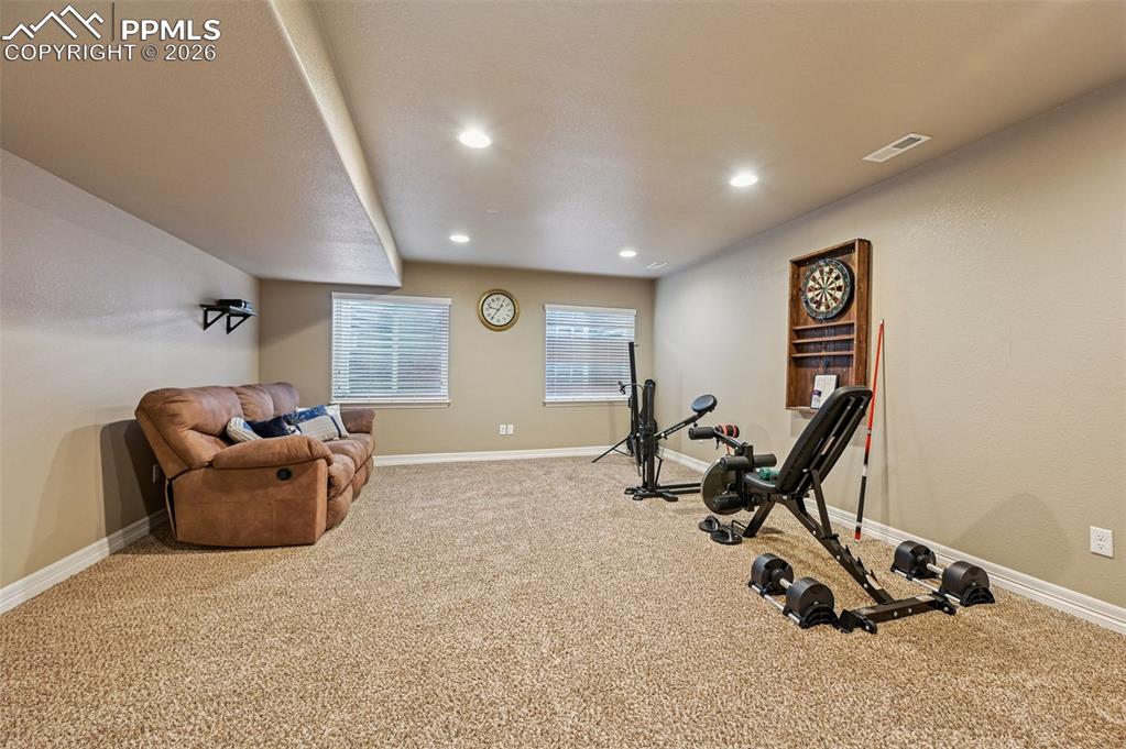 Image 34 of 38: Exercise room with light carpet and recessed lighting