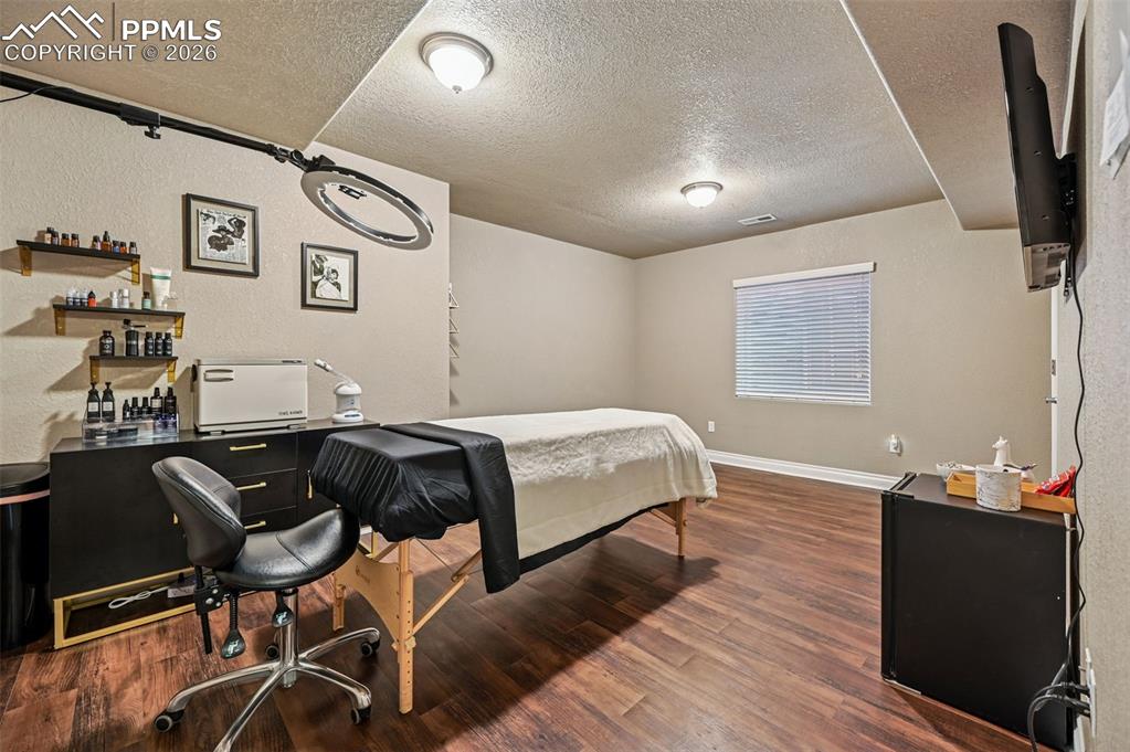 Image 38 of 38: Bedroom featuring a textured ceiling, dark wood-style floors, and a texture