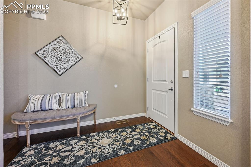 Image 8 of 38: Entrance foyer featuring a chandelier and dark wood-style flooring