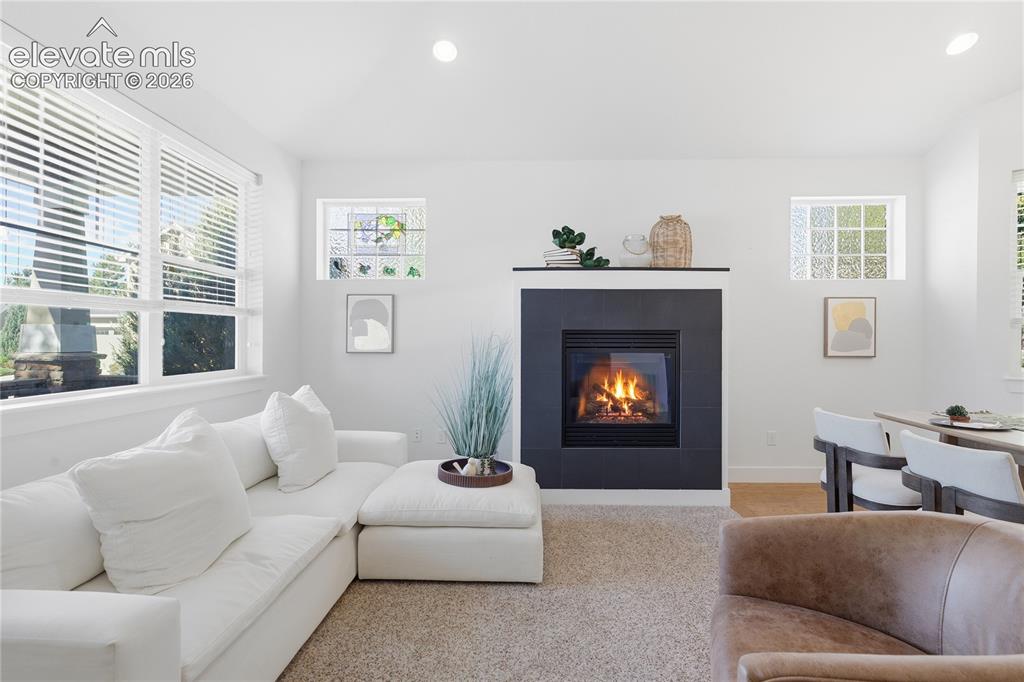 Image 10 of 24: Fireplace with a dark tile surround and hearth, featuring a contrasting lig