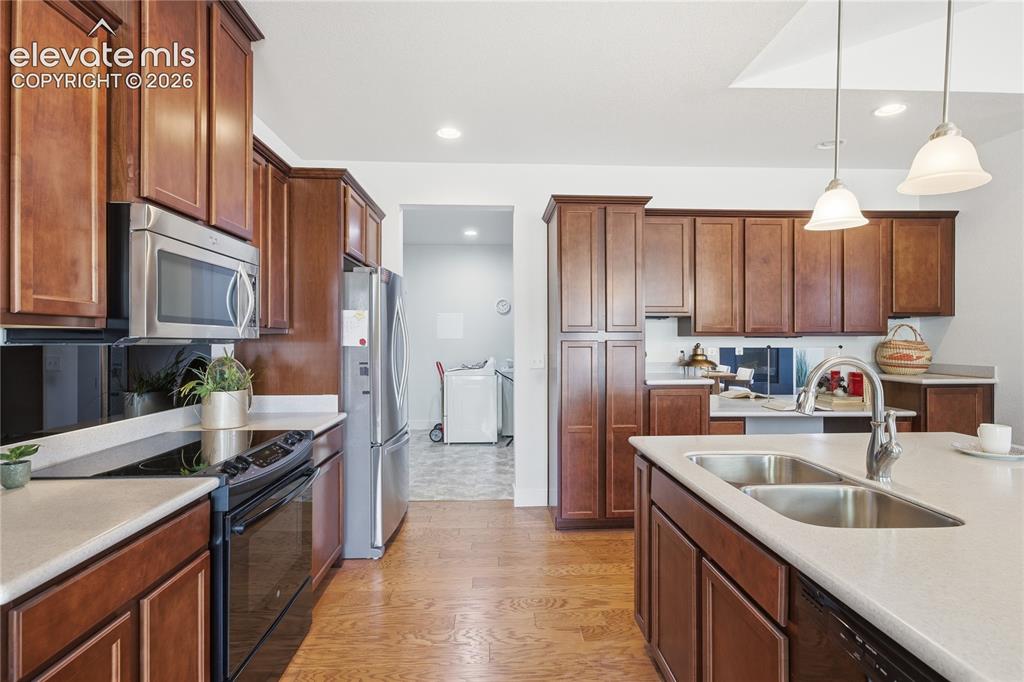 Image 14 of 24: Kitchen featuring wood-finish flooring, recessed lighting, and an island wi