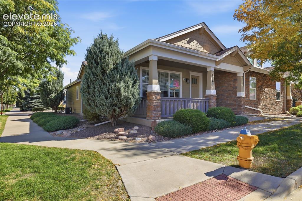 Image 2 of 24: Front exterior featuring a covered porch, stone facade accents, decorative
