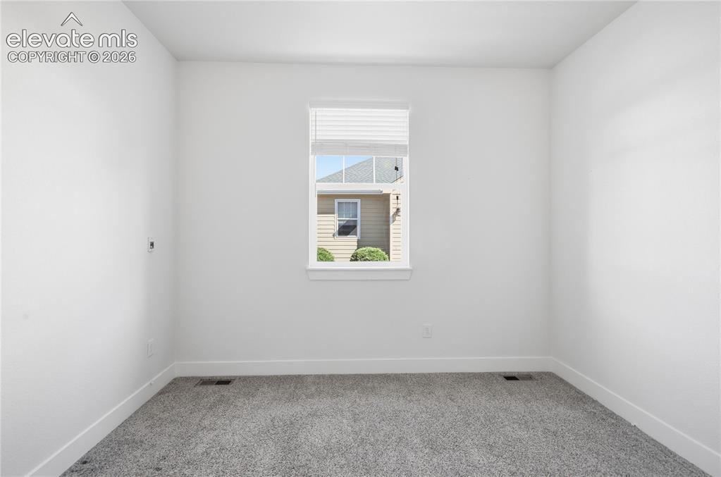 Image 20 of 24: Neutral wall paint with carpet flooring and window with blinds