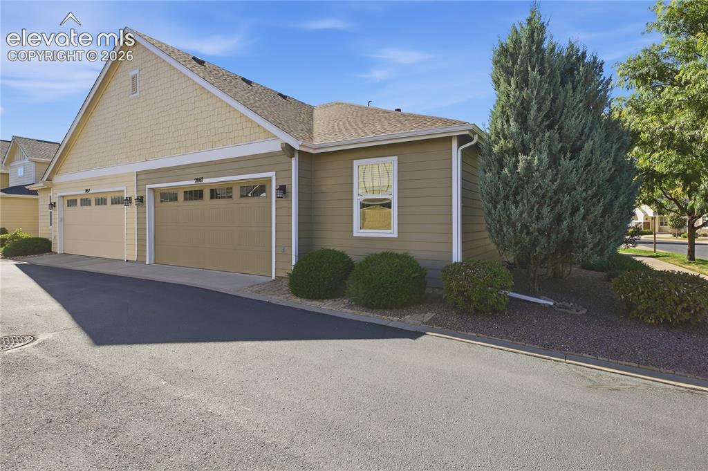 Image 24 of 24: Two-car garage with overhead doors featuring upper window panels