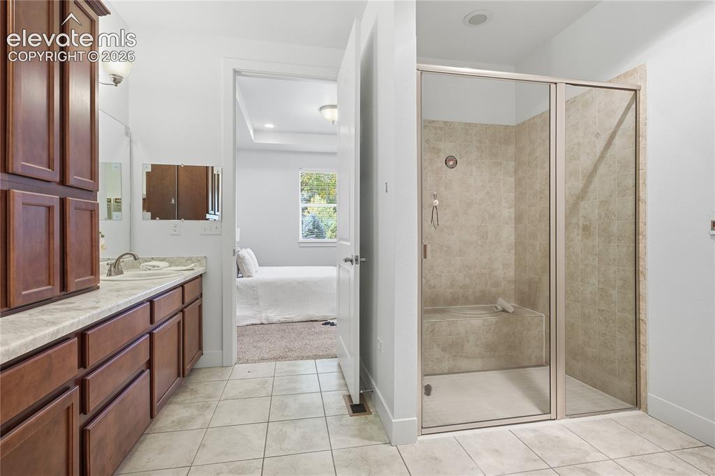 Image 7 of 24: Walk-in shower with a built-in bench, glass enclosure, and tiled walls