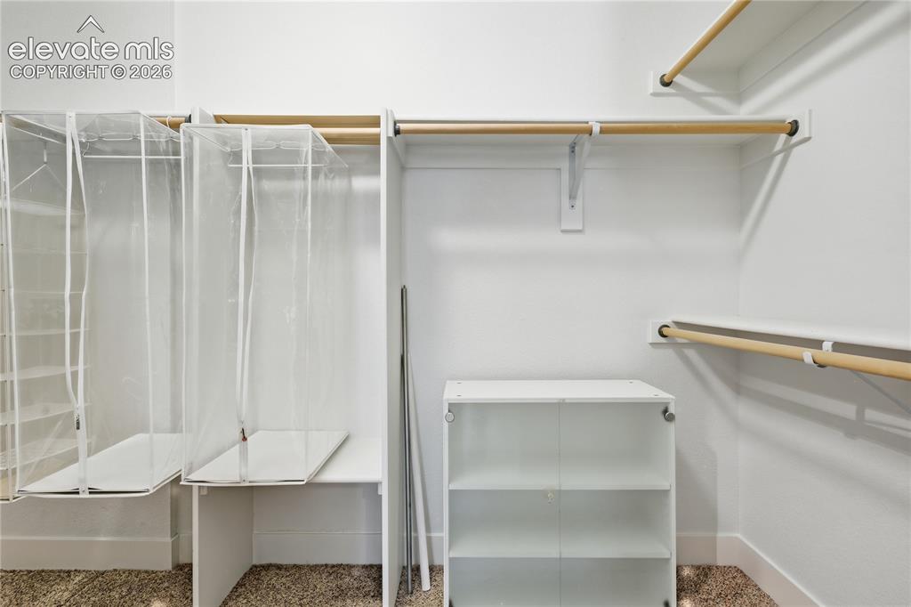 Image 8 of 24: Built-in shelving, wood-finish hanging rods, and an integrated storage unit