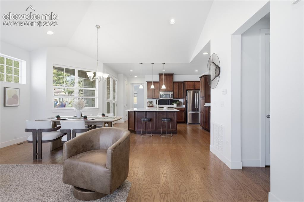 Image 9 of 24: Open-concept living area featuring vaulted ceilings, recessed lighting, woo
