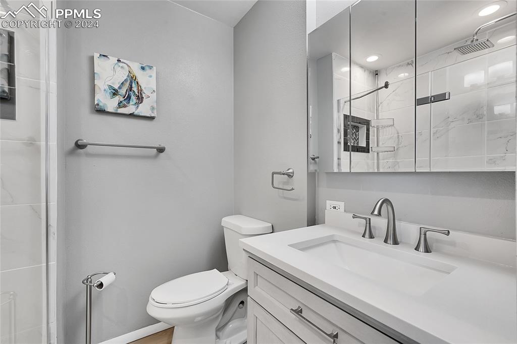 Image 17 of 42: Bathroom featuring vanity, toilet, and walk in shower