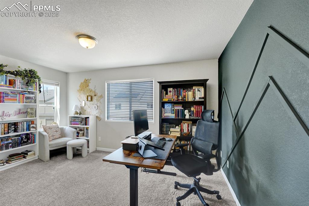 Image 18 of 25: The office is stunning with a gorgeous accent wall.