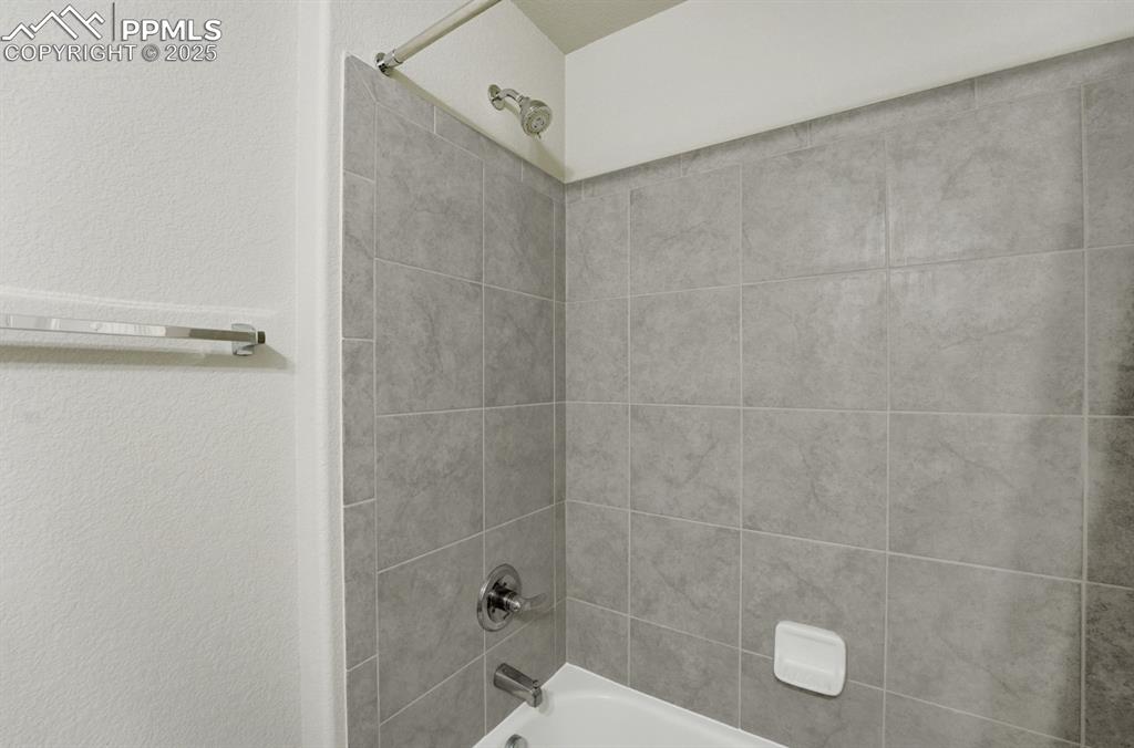 Image 21 of 25: Upper level full bath/tile.