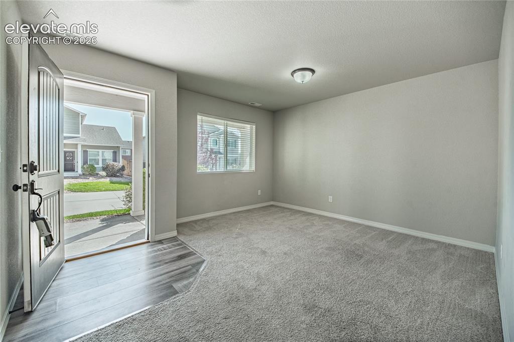 Image 13 of 35: Entryway featuring wood-finish flooring transitioning to carpet, a window w