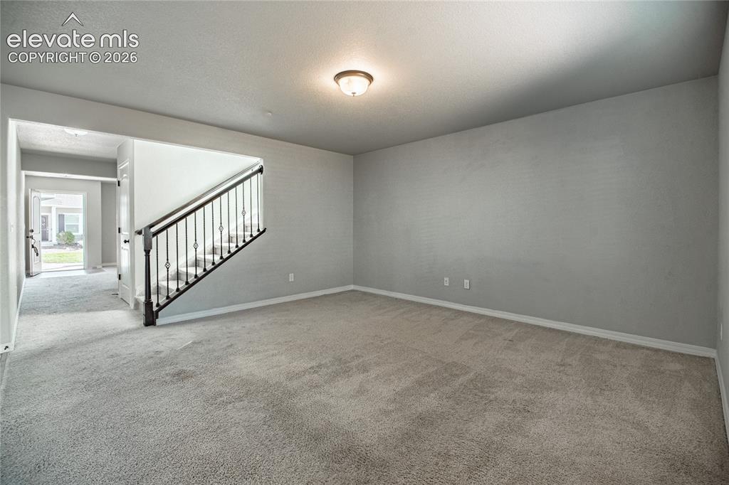 Image 14 of 35: Carpeted room with light gray walls, an overhead flush-mount light fixture,