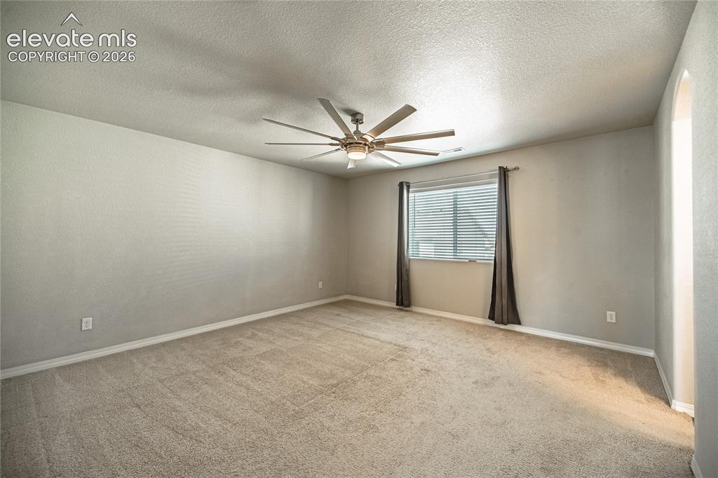 Image 18 of 35: Carpeted flooring, window with blinds, ceiling fan with integrated lighting