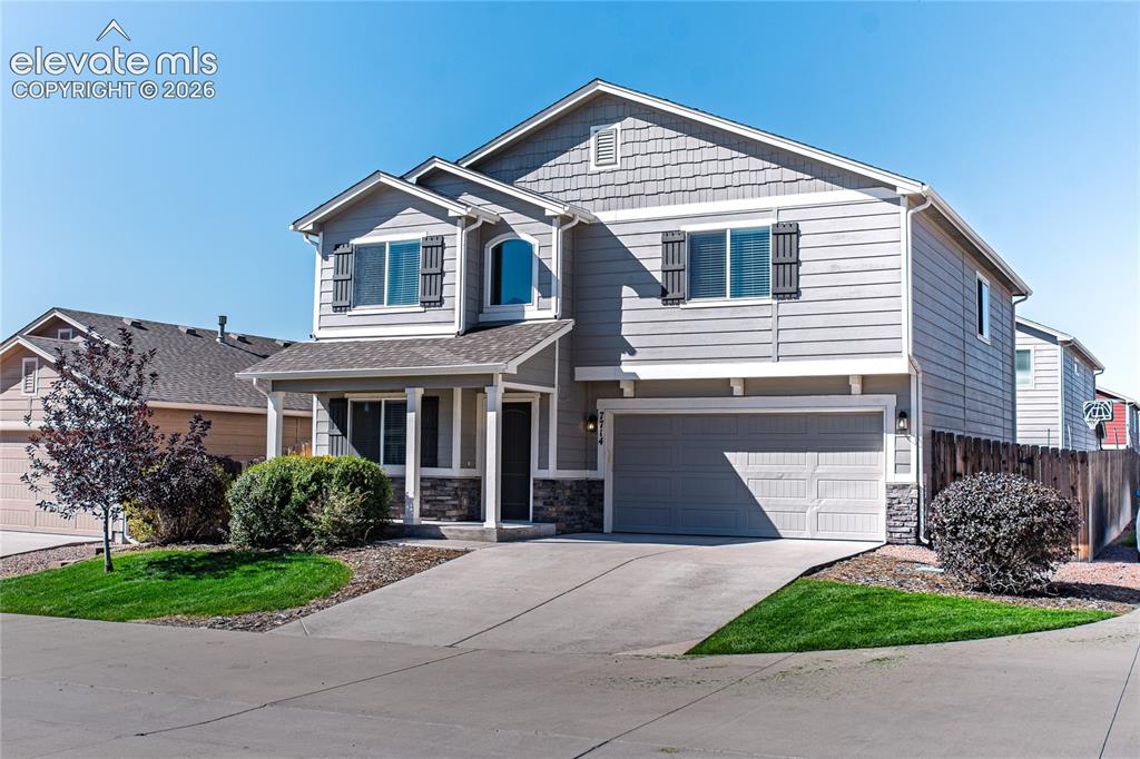 Image 2 of 35: Two-story exterior with a covered entry, attached garage, and multi-texture