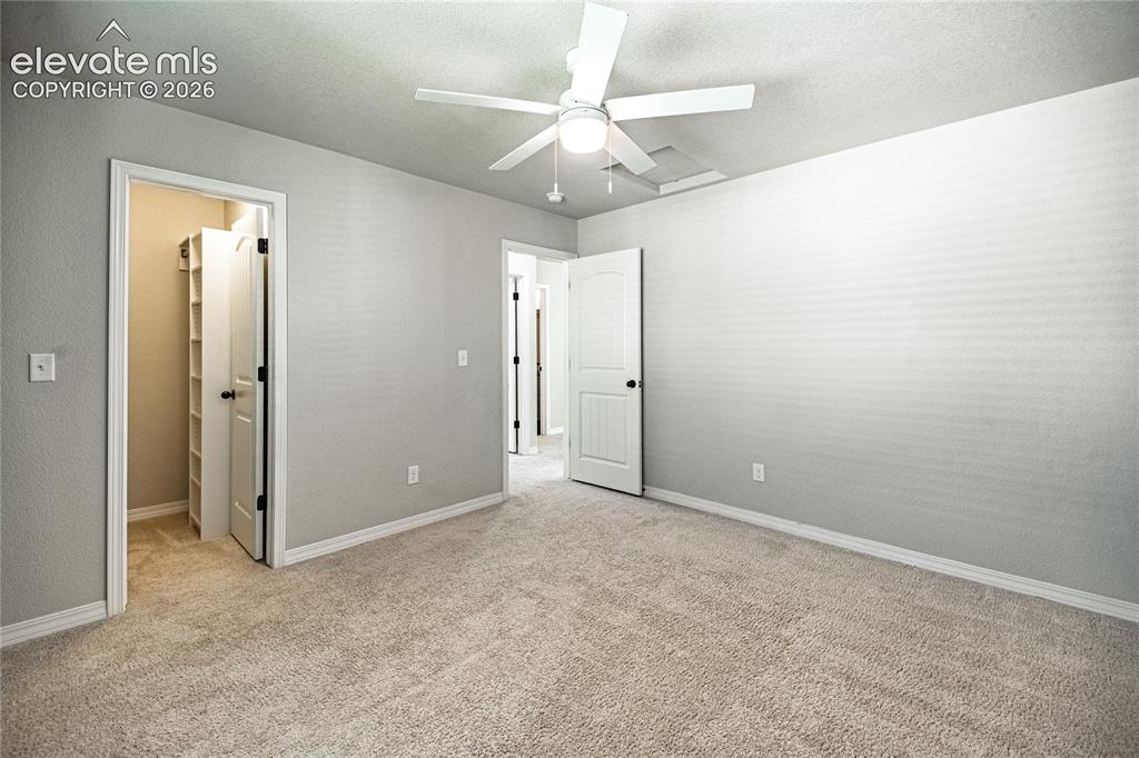 Image 24 of 35: Plush carpeting, a ceiling fan with integrated lighting, and a closet with