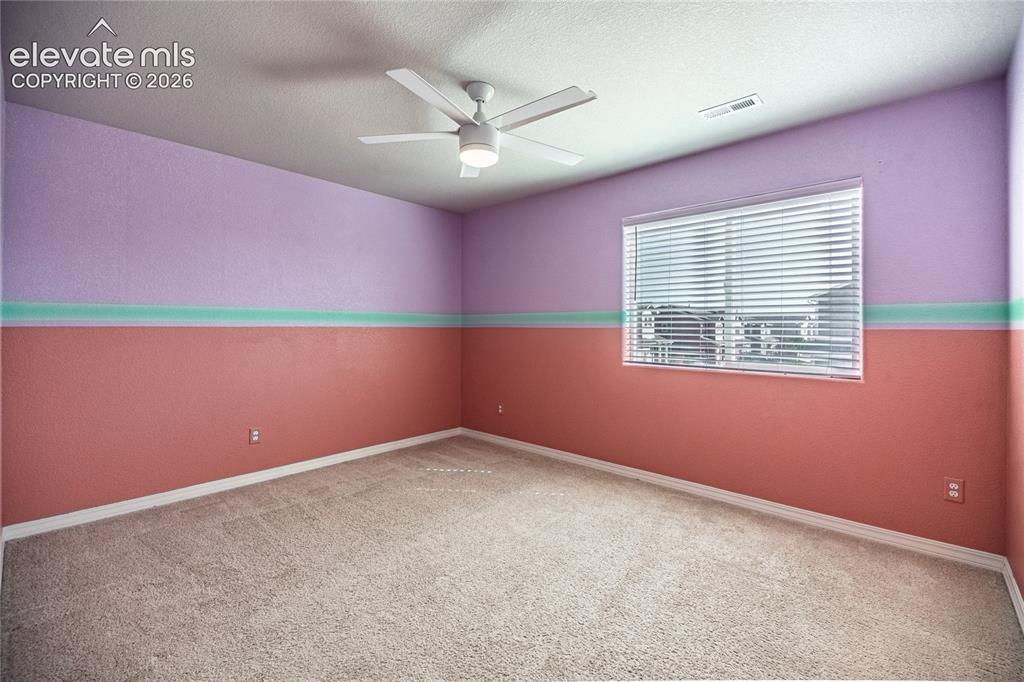 Image 25 of 35: Textured walls with a two-tone paint scheme, a single window with blinds, a