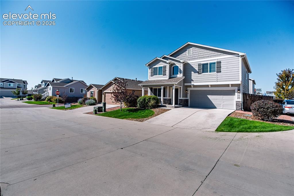 Image 3 of 35: Two-story residence with a gray siding exterior, an attached two-car garage