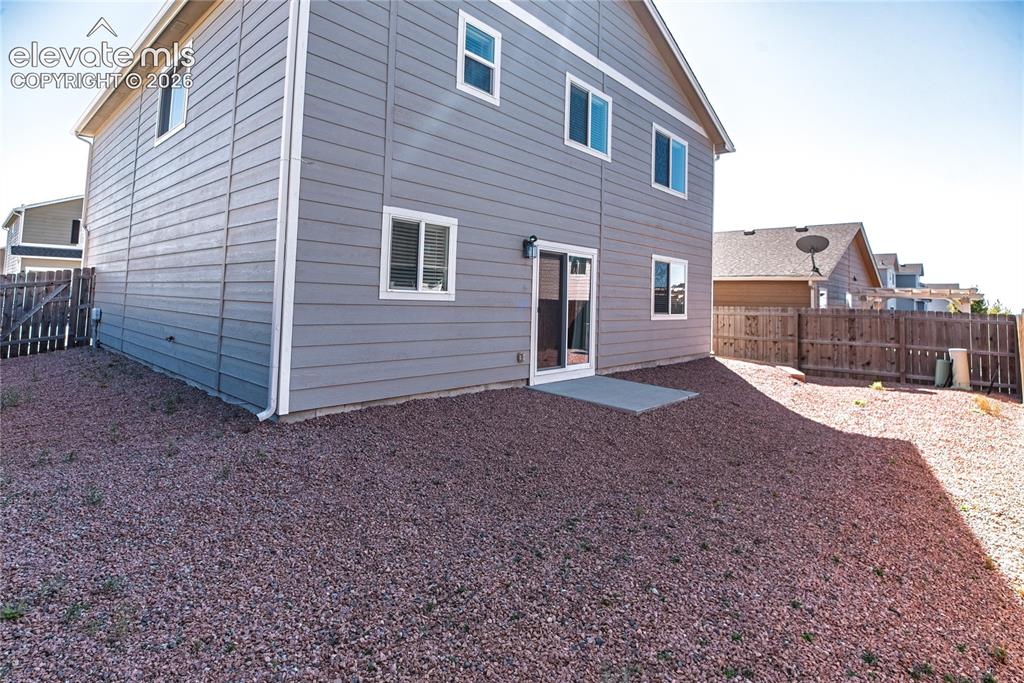 Image 31 of 35: Two-story exterior with horizontal siding, multiple windows, a sliding glas