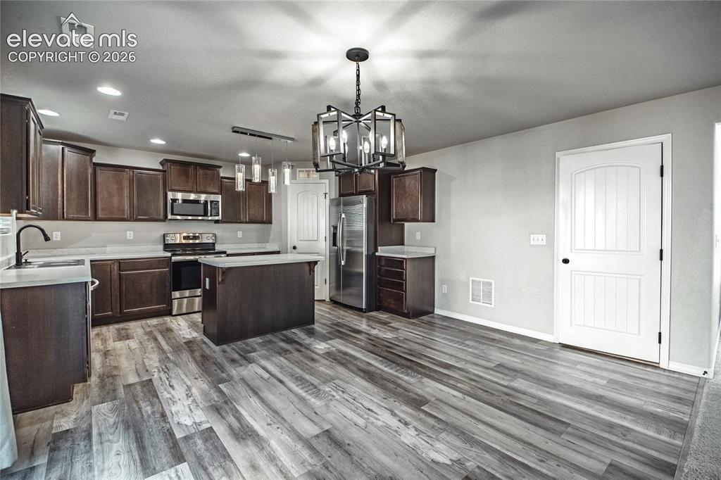 Image 7 of 35: Wood-finish flooring throughout, dark wood-finish cabinetry, stainless stee