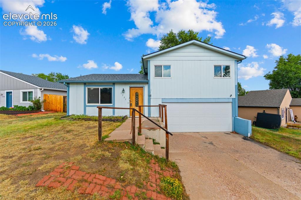 Image 1 of 20: Split-level residence featuring light blue siding with white trim accents a