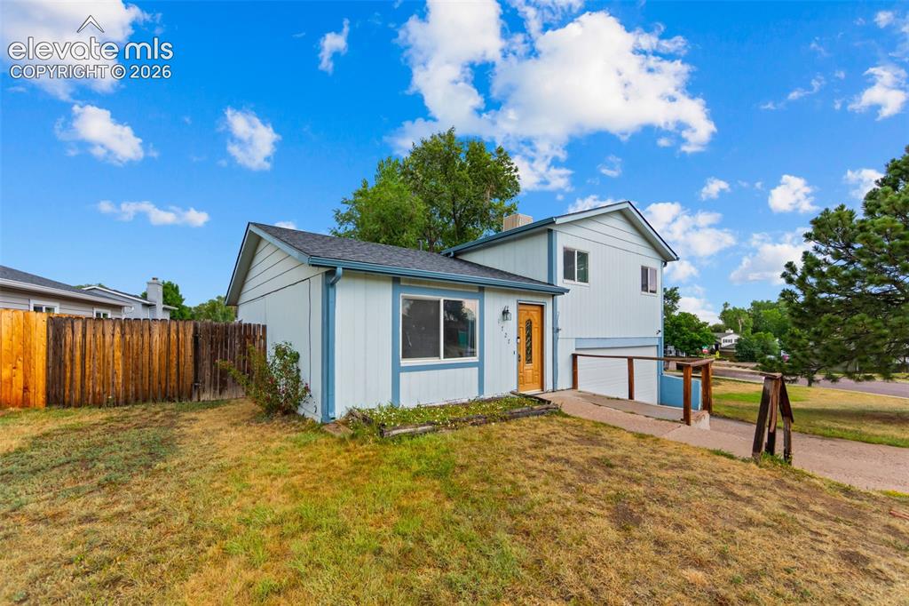 Image 3 of 20: Exterior featuring light blue siding with white trim, a wood-finish front d