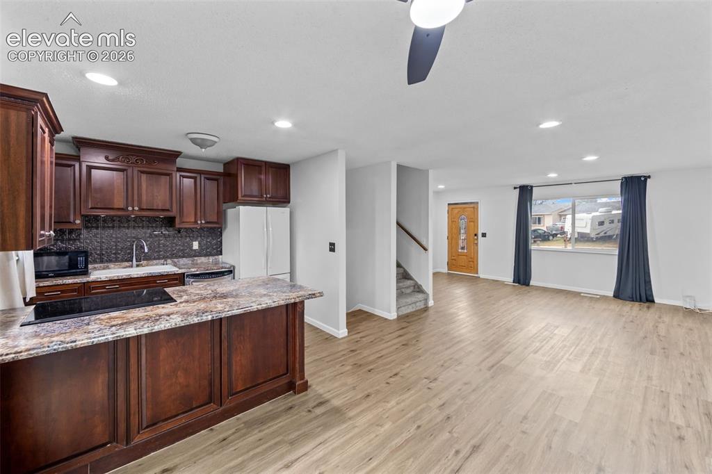 Image 6 of 20: Kitchen and living area featuring wood-finish flooring, recessed lighting, 