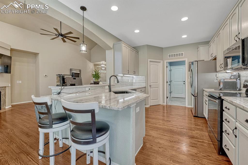 Image 10 of 41: Kitchen featuring stainless steel-finished appliances, a breakfast bar area