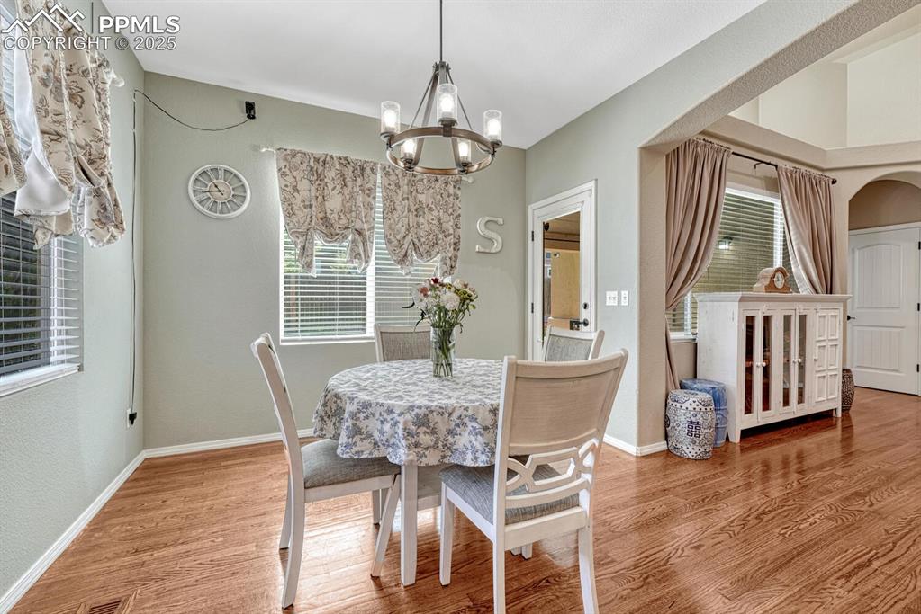 Image 15 of 41: This stunning dining room is elevated by its gorgeous wood floors, exquisit