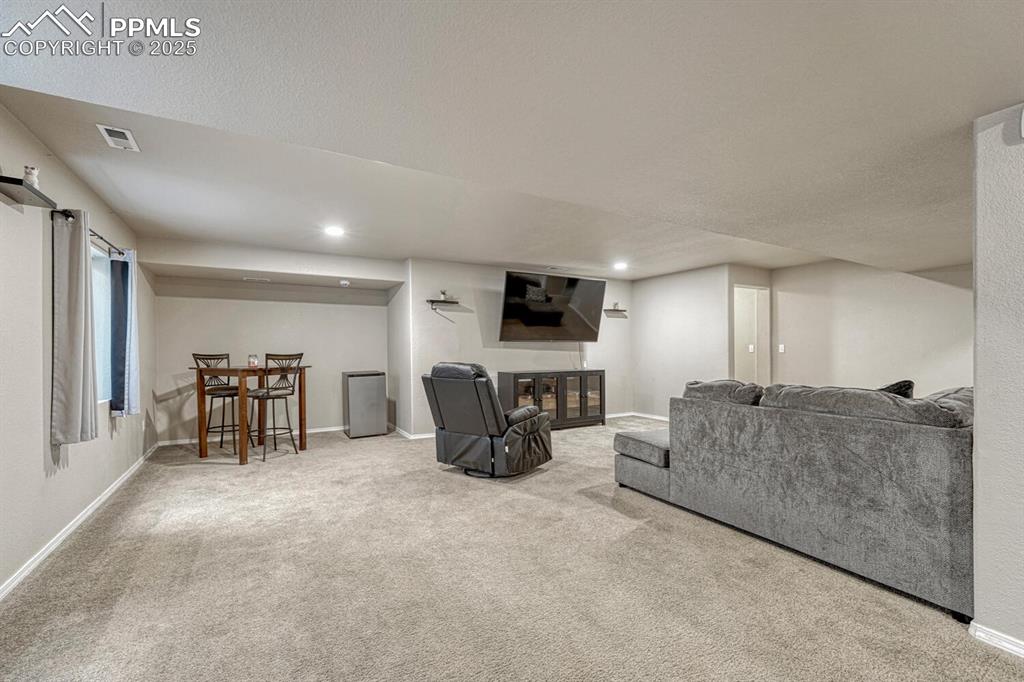 Image 21 of 41: Experience the warmth and comfort of a carpeted living area, perfectly comp