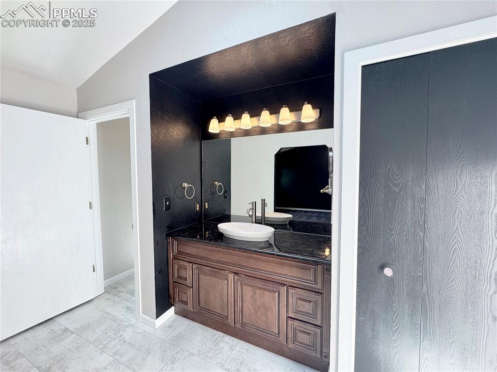 Image 11 of 28: Bathroom with vanity and lofted ceiling