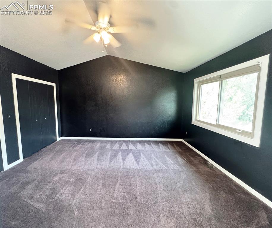 Image 14 of 28: Unfurnished bedroom with vaulted ceiling, a closet, carpet floors, a ceilin