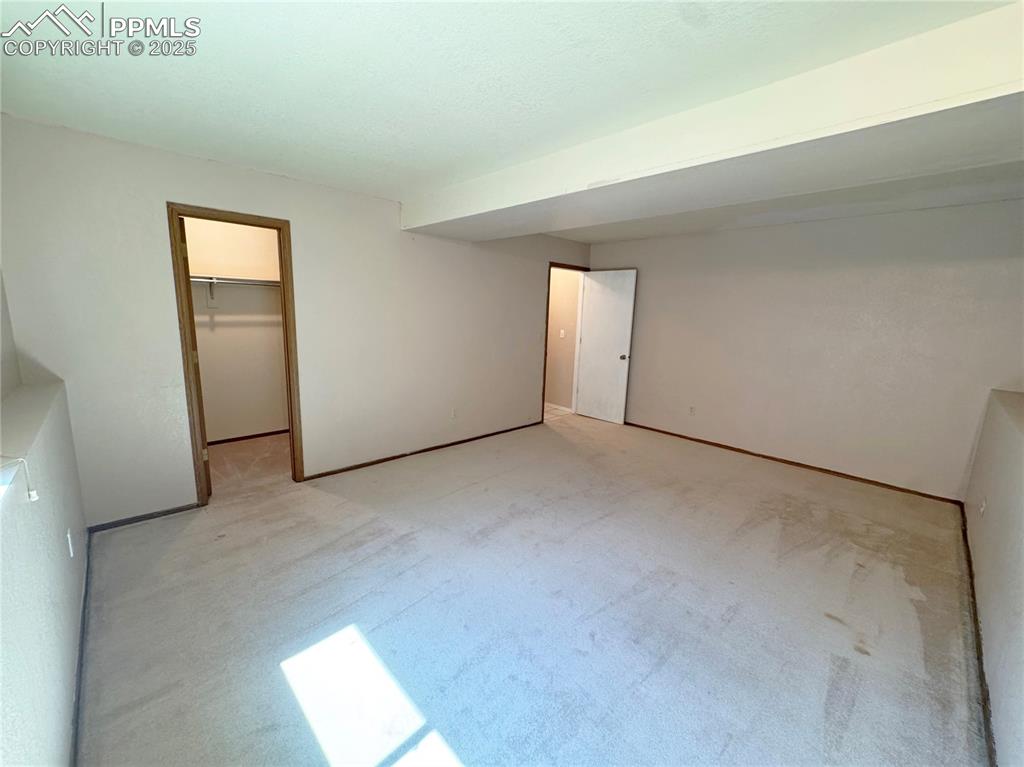 Image 18 of 28: Unfurnished bedroom with a spacious closet and carpet flooring