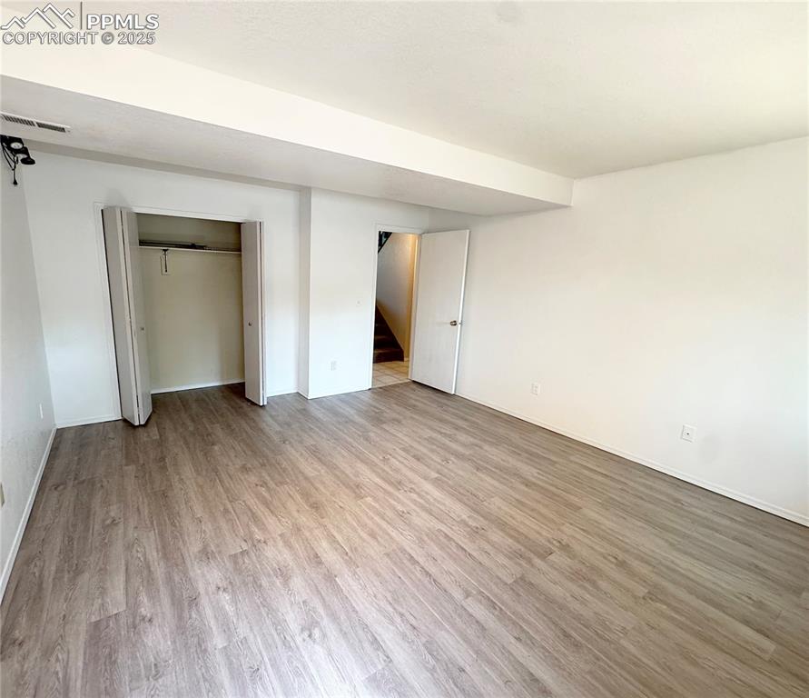 Image 24 of 28: Unfurnished bedroom featuring light wood finished floors and a closet