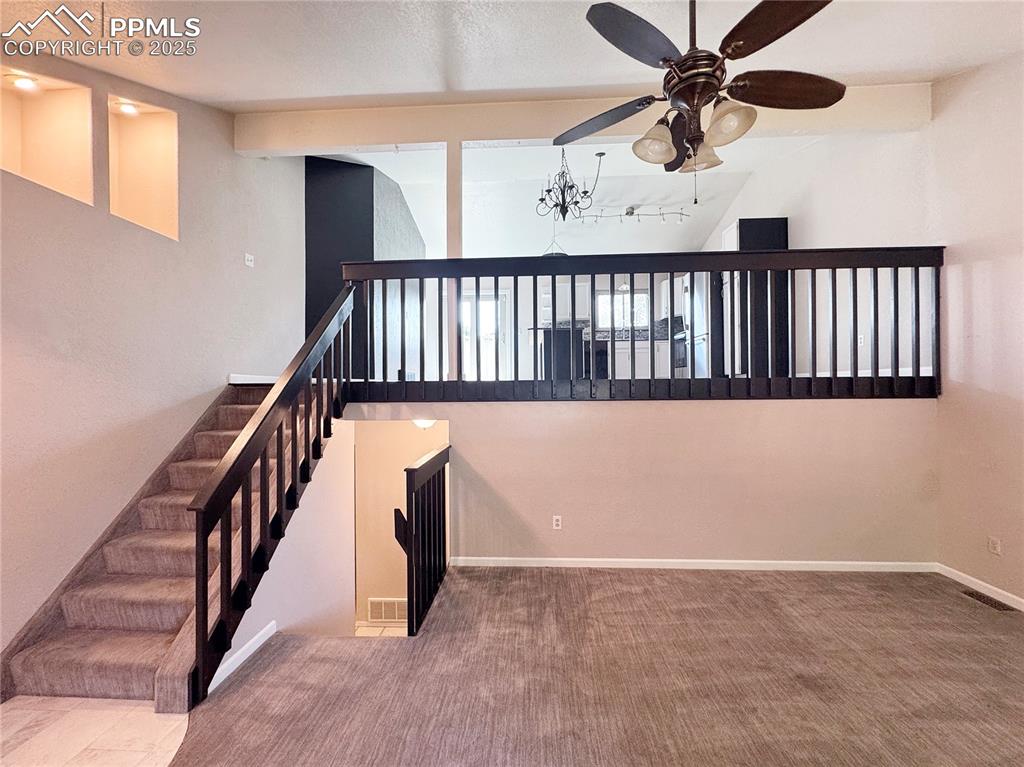 Image 3 of 28: Stairs featuring carpet flooring, lofted ceiling, a textured ceiling, a cha