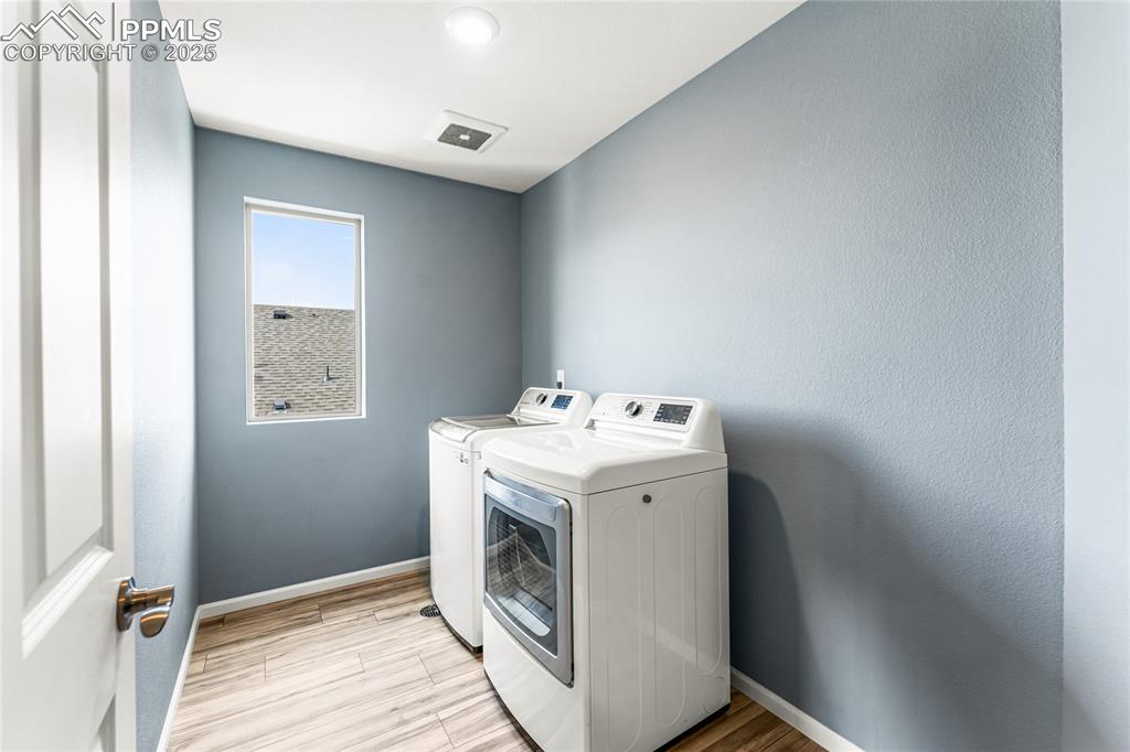Image 26 of 48: Clothes washing area featuring baseboards, light wood-style flooring, separ
