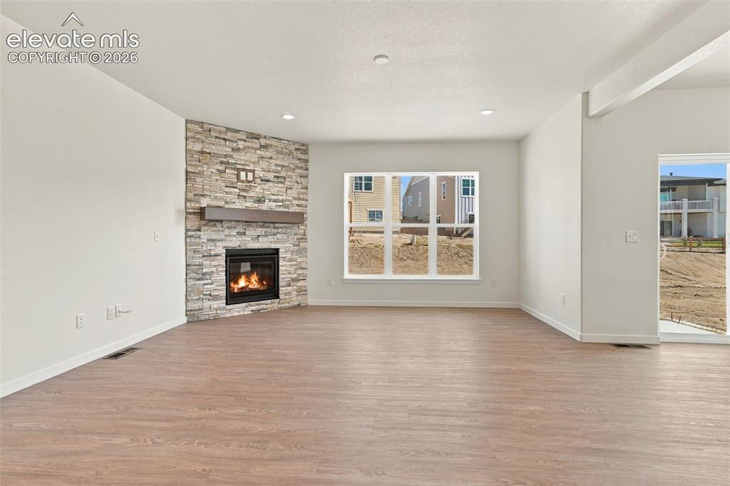 Image 10 of 49: The Great Room features a Gas fireplace with stone extended to the ceiling,