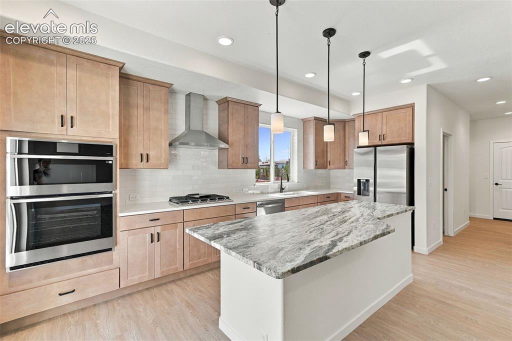 Image 18 of 49: Modern kitchen featuring stainless steel appliances, light maple cabinets w