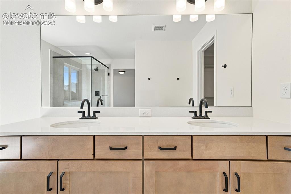 Image 28 of 49: Double Vanities with undermount sinks, maple cabinets with pecan stain, mat