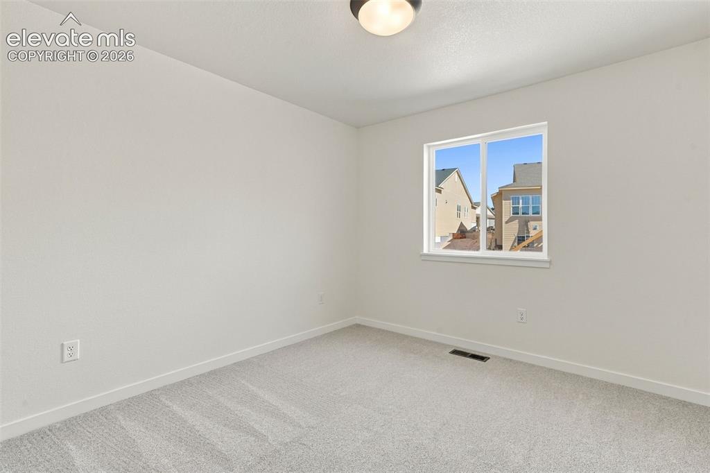 Image 31 of 49: Bedroom 2 features with soft white walls and plush gray carpeting