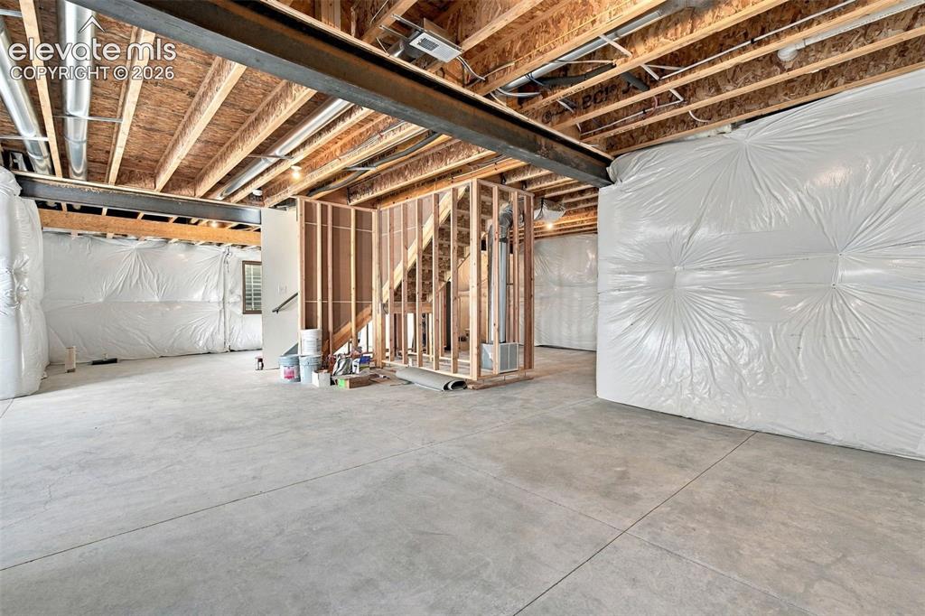 Image 39 of 49: Unfinished basement with exposed ceiling joists, and concrete flooring
