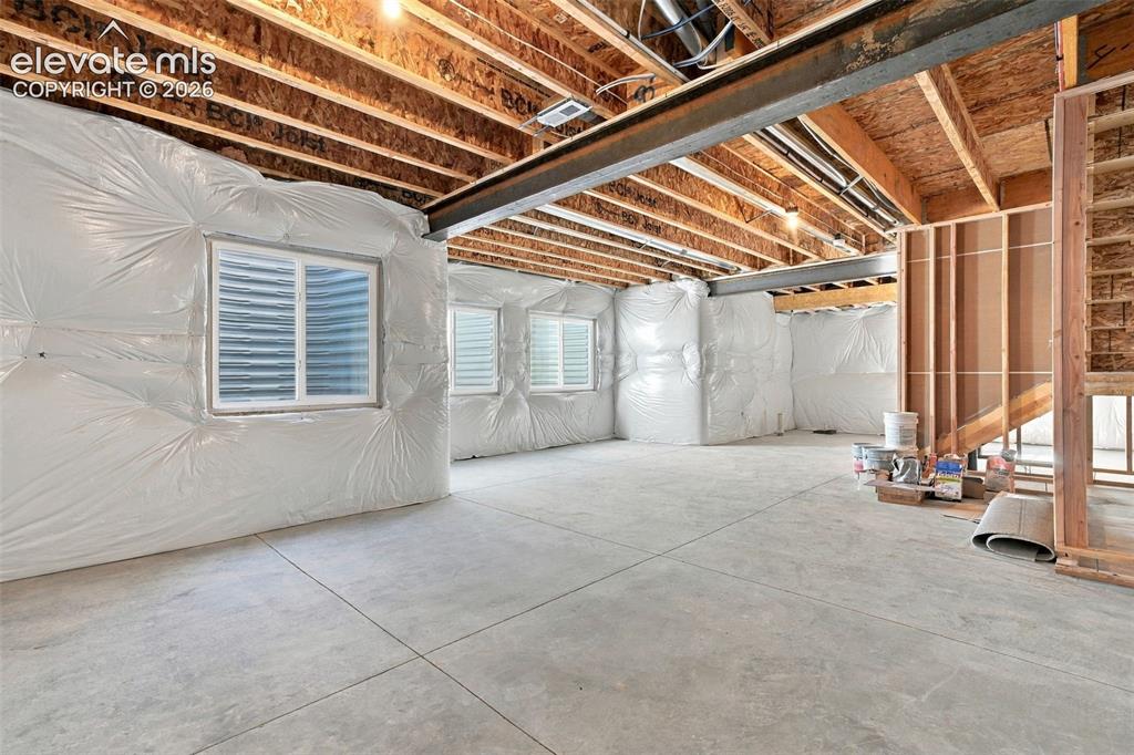 Image 40 of 49: Unfinished basement with exposed ceiling joists, and concrete flooring
