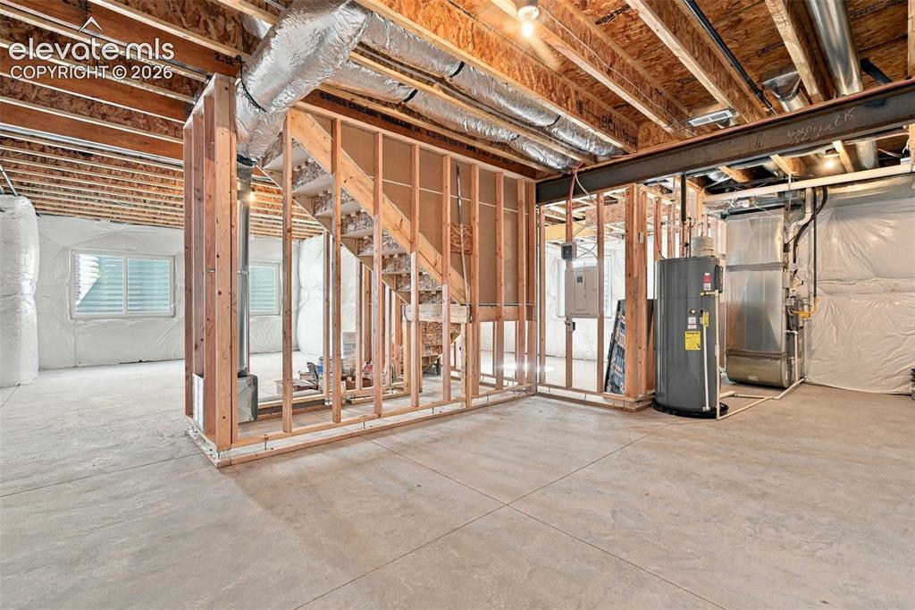 Image 41 of 49: Unfinished basement with exposed ceiling joists, and concrete flooring