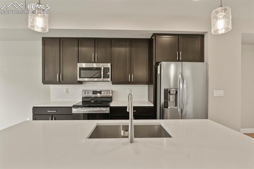 Image 10 of 29: Kitchen with stainless appliances, granite countertops and decorative backs