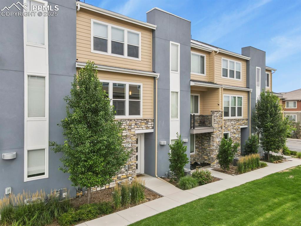 Image 2 of 29: Townhouse featuring stone and wood siding