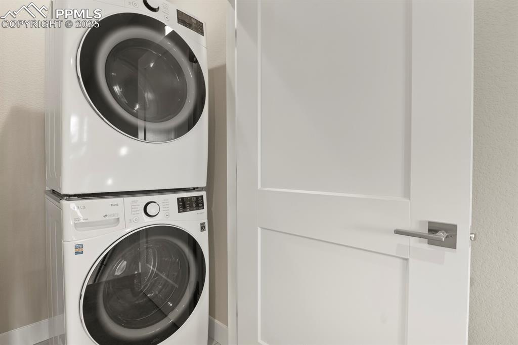 Image 24 of 29: Laundry area featuring stacked washer and clothes dryer