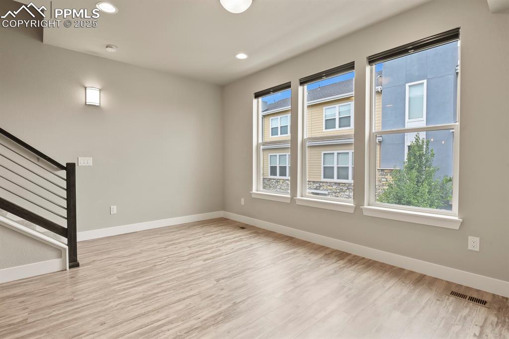 Image 7 of 29: Living room with stairway to upper level, recessed lighting and wood finish